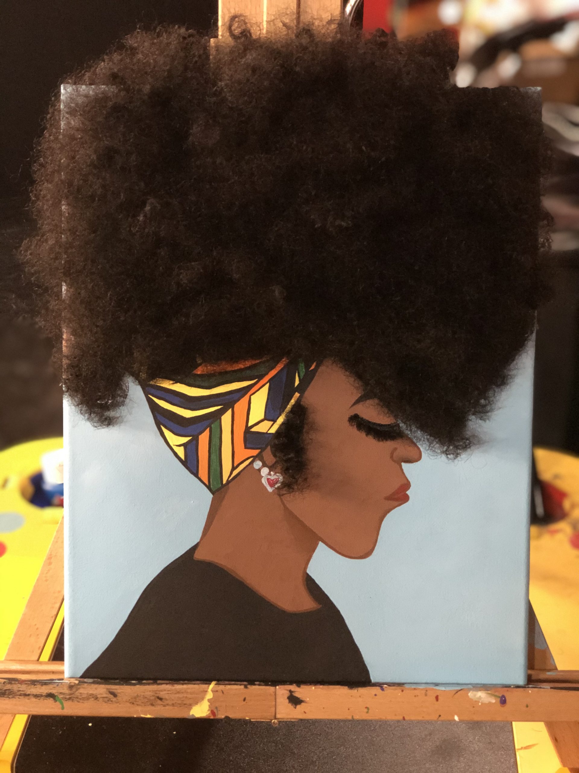 A painting of a woman with a colorful scarf and natural hair, purchased by Lisa Carter of Jersey City, N.J.